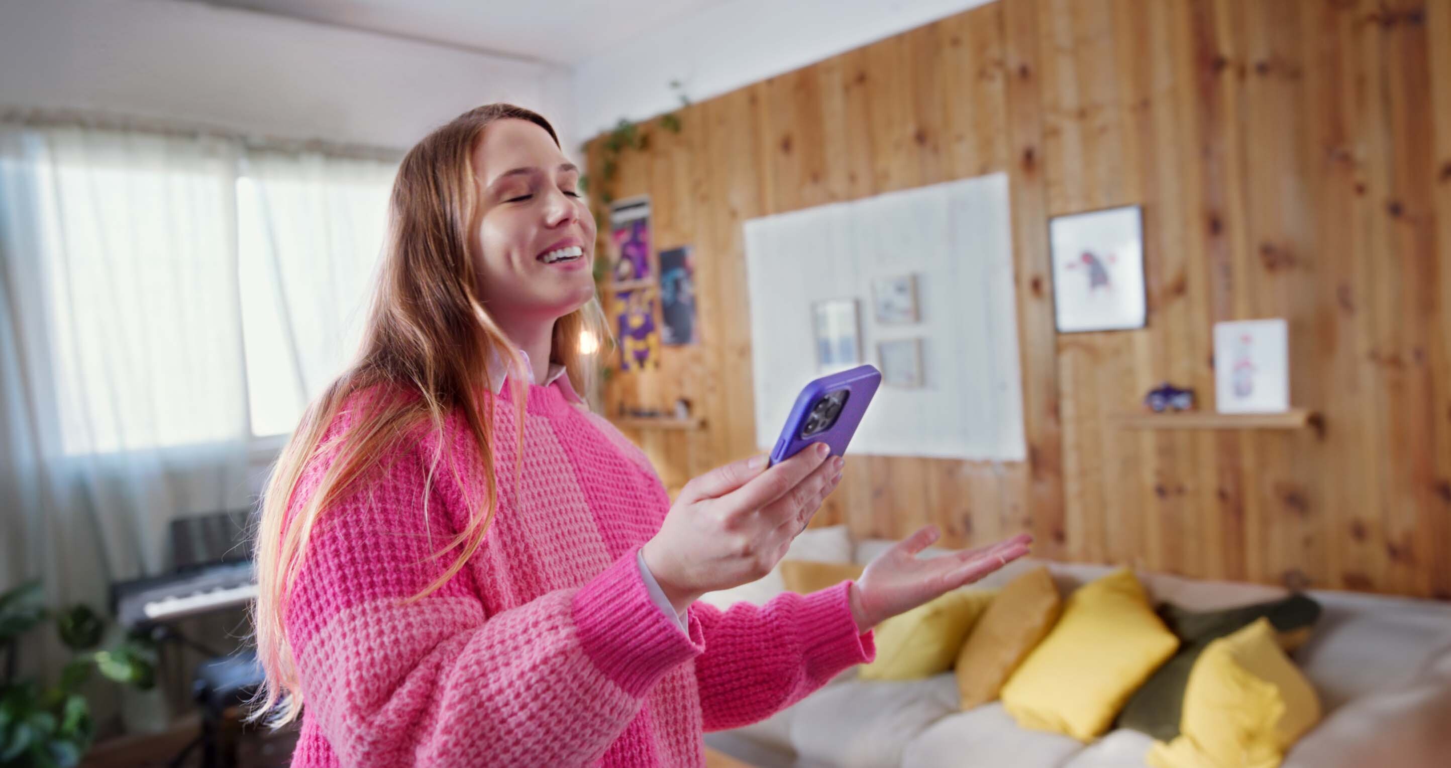 A girl singing with headphones connected to a phone